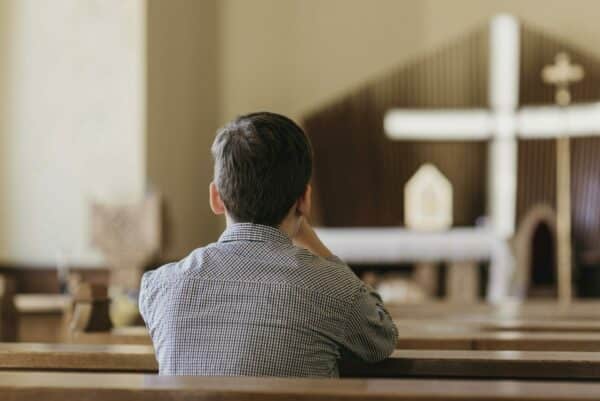 Prière église Homme qui prie dans une église lors d'une cérémonie funéraire